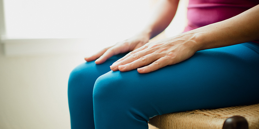 Woman meditating with hands resting atop her knees